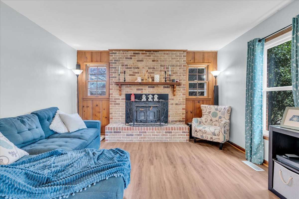 Cozy living room with wood-burning fireplace and preserved original character, perfect for relaxing or entertaining.