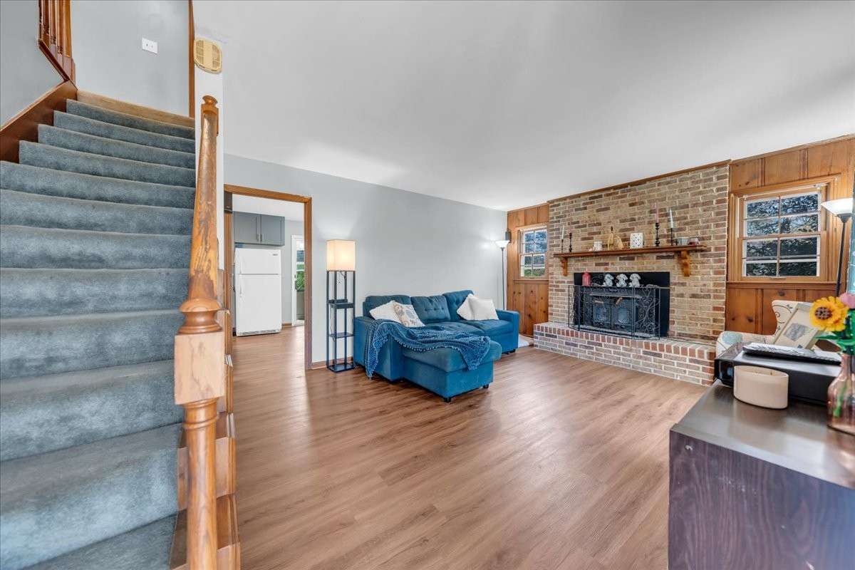 Cozy living room with wood-burning fireplace and preserved original character and built in surround sound, perfect for relaxing or entertaining.