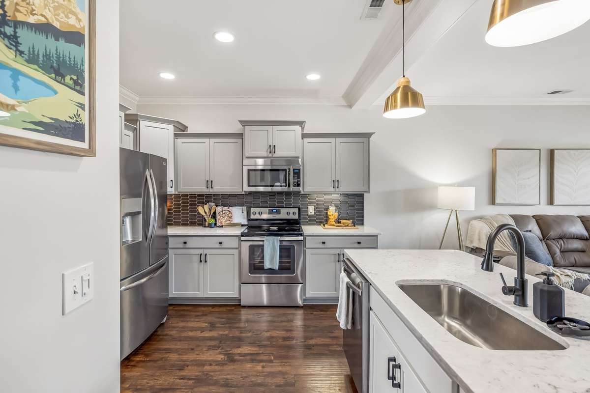 THE KITCHEN IS OVERSIZED AND OPEN WITH A 6' ISLAND, FARMHOUSE SINK, QUARTZ COUNTERTOPS, CUSTOM CABINETS, TILE BACKSPLASH, UNDER-CABINET LIGHTING+PENDANT LIGHTING TO PULL IT ALL TOGETHER, ALL STAINLESS STEEL APP REMAIN + A DOUBLE DOOR PANTRY!