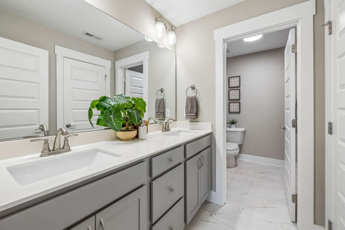 THIS JACK AND JILL STYLE BATH IS PRACTICAL AND CONVENIENT WITH DOUBLE VANITIES, A LINEN CLOSET AND VERY LARGE SEPARATE SHOWER & WATER CLOSET. THERE IS ROOM FOR SHELVING OR EVEN A LINEN CABINET.