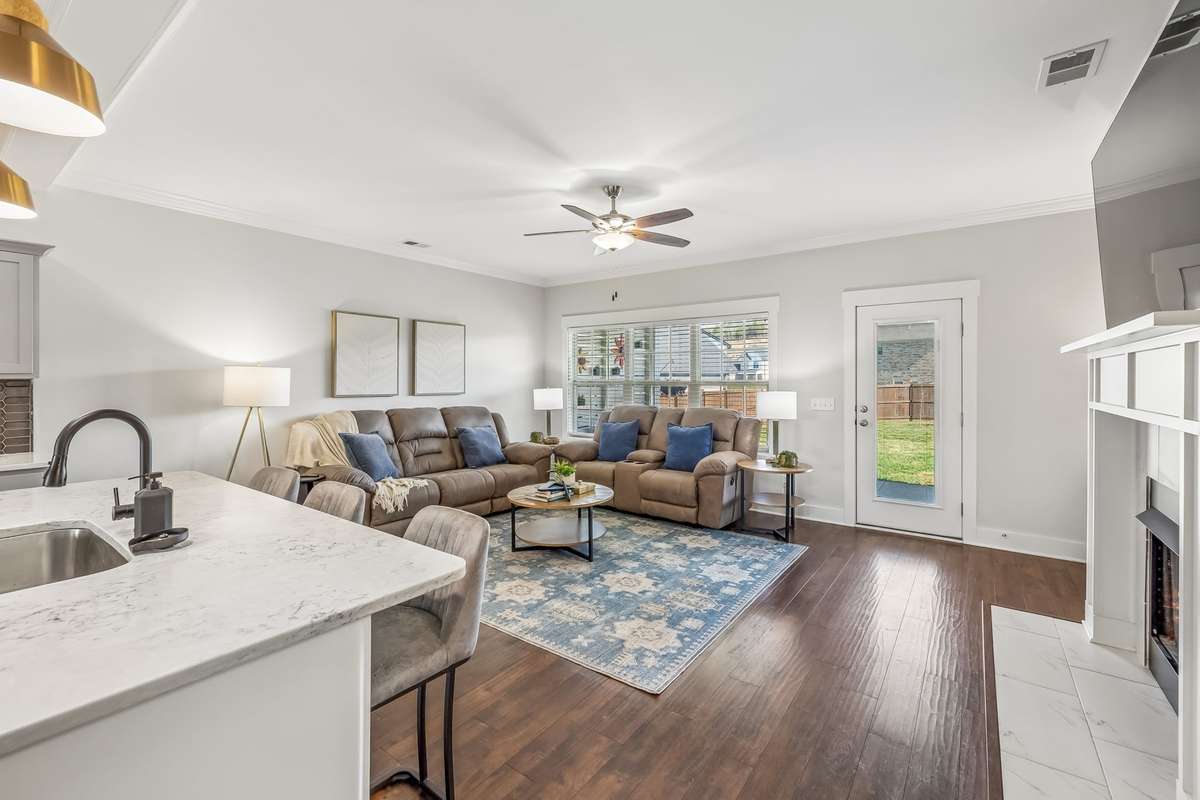 THE LIVING ROOM HAS A GAS FIREPLACE WITH MANTLE AND TILE SURROUND.