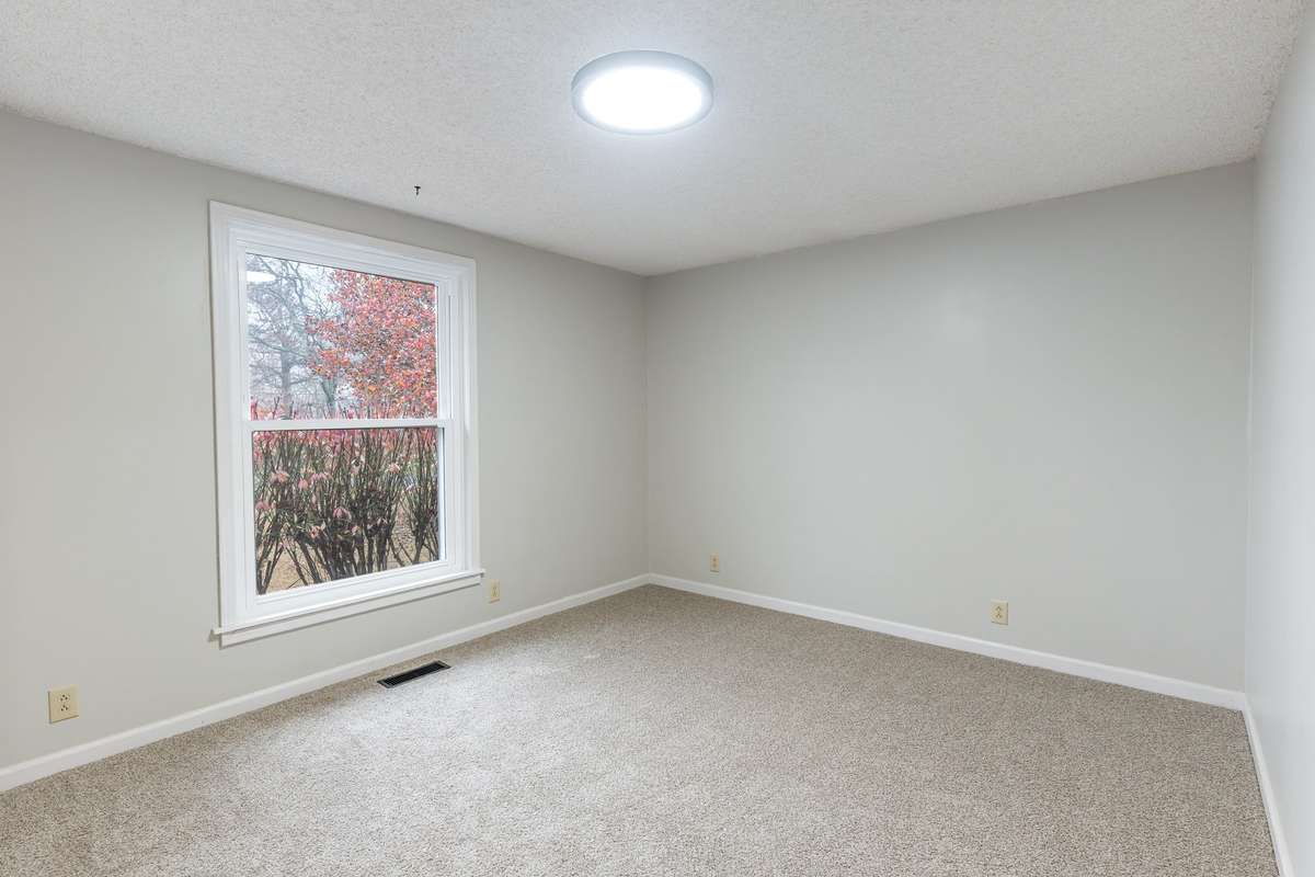 Bedroom 2 offers a bright and welcoming feel with its large window overlooking the mature landscaping outside along with fresh paint and brand-new plush carpet