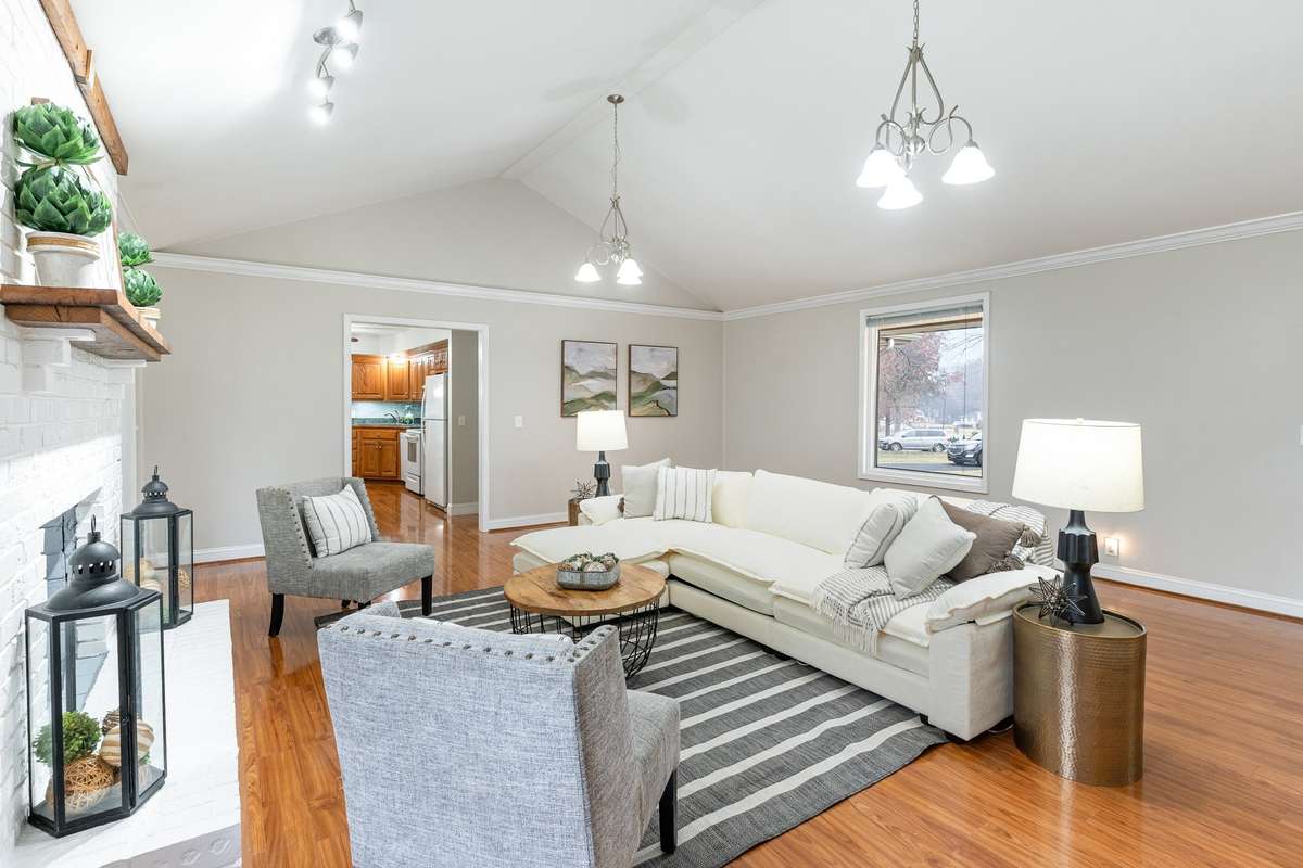 The spacious living room features vaulted ceilings and a cozy fireplace, creating an inviting space perfect for relaxing or entertaining