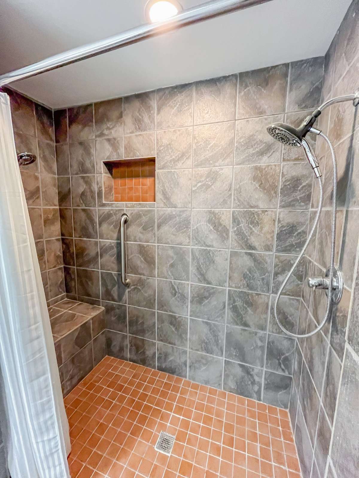 Primary Bath located in the Primary Bedroom featuring an exquisite walk-in Tiled Shower with Grab bars