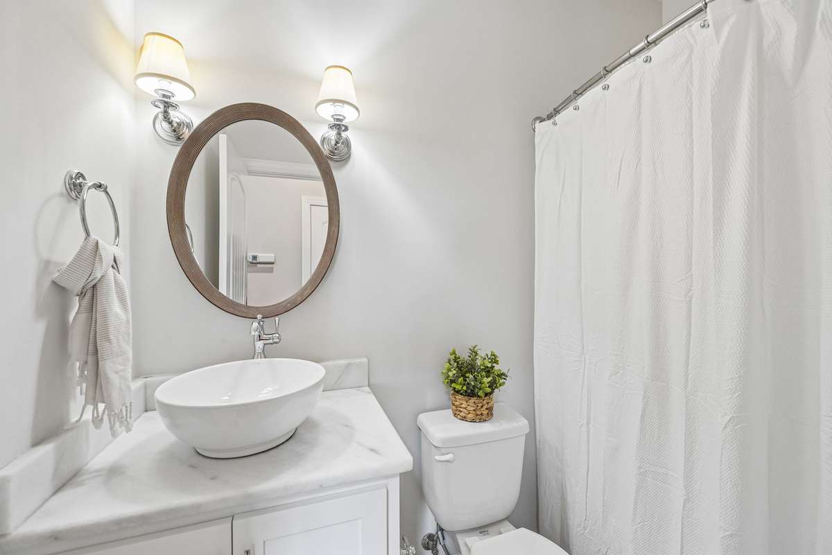 Second bathroom on main level with shower/tub combo and marble countertops