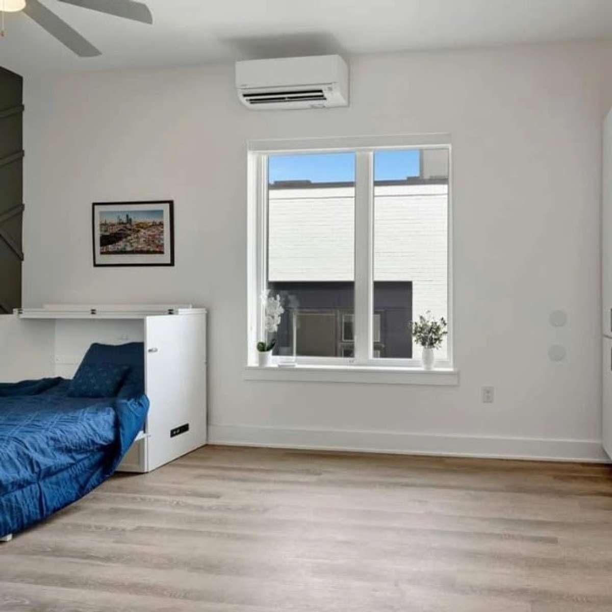Another view of the window with energy efficient mini split HVAC unit near the ceiling.