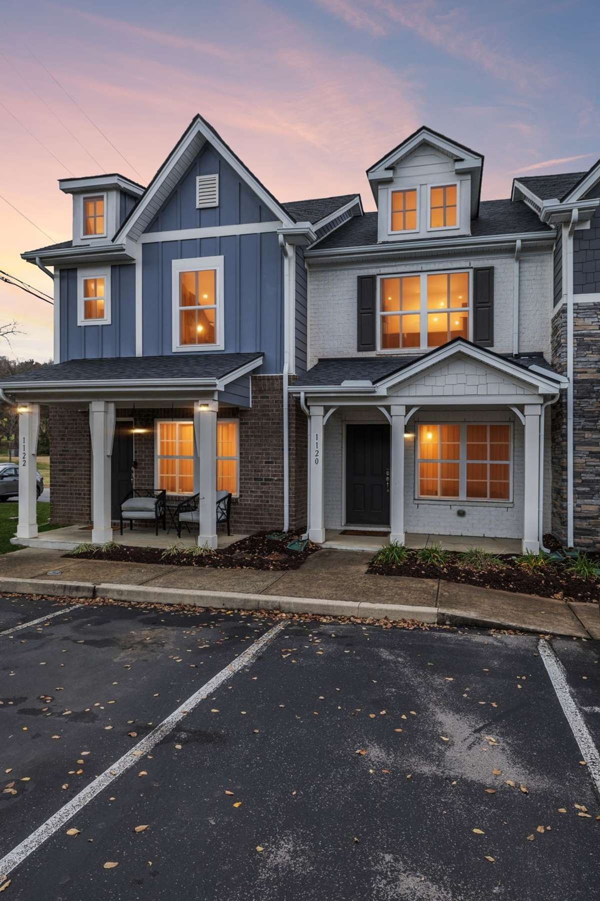 Beautiful evening view of the home’s exterior, capturing the warm curb appeal and the charming ambiance of Park Place at Charlotte at sunset.