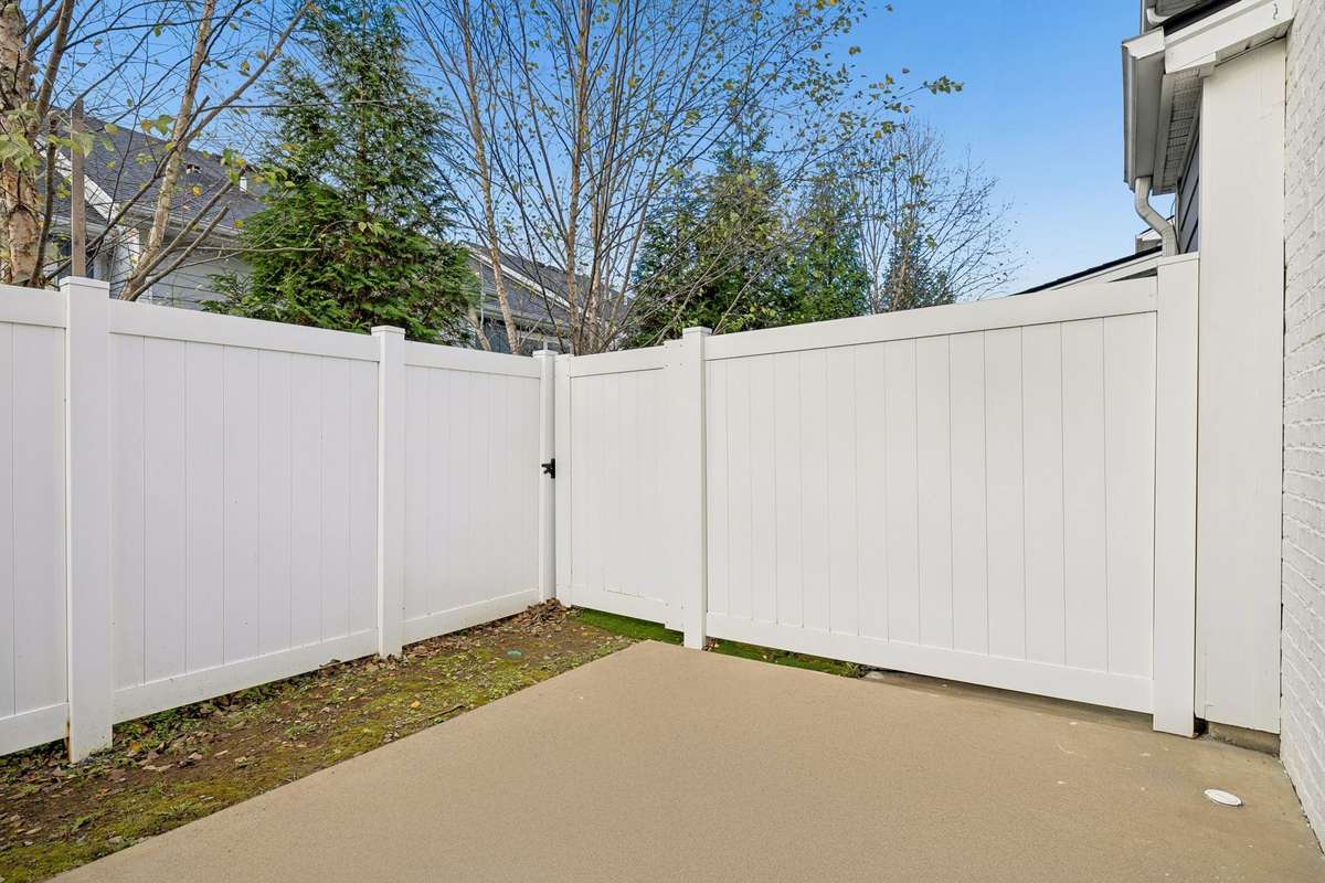 Private fenced back patio with a concrete pad—perfect for grilling, fire-pit evenings, or outdoor gatherings. Includes a convenient outdoor storage closet for added functionality.