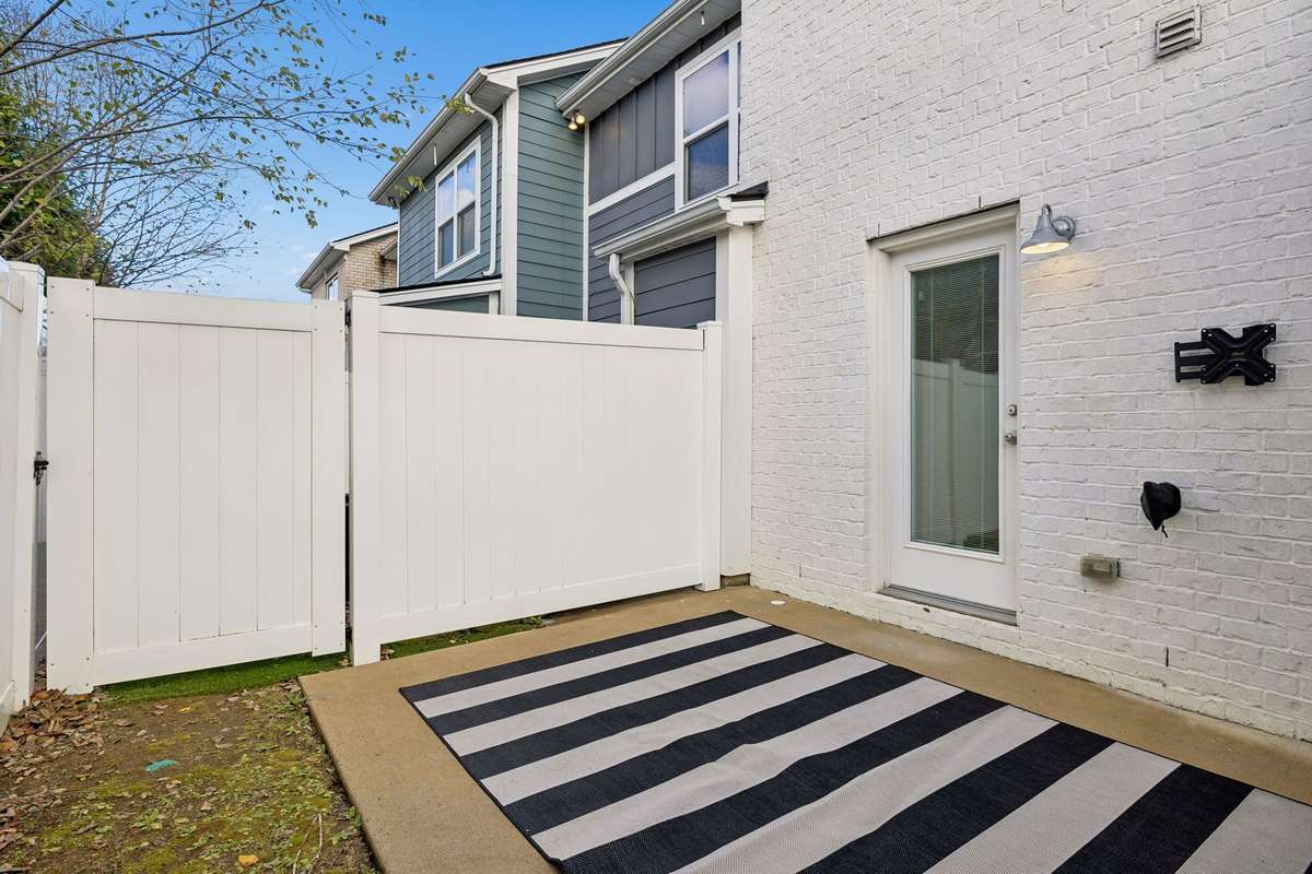 Back patio featuring a custom-sized outdoor rug that can remain with an acceptable offer, adding comfort and style to this private, fenced outdoor space.