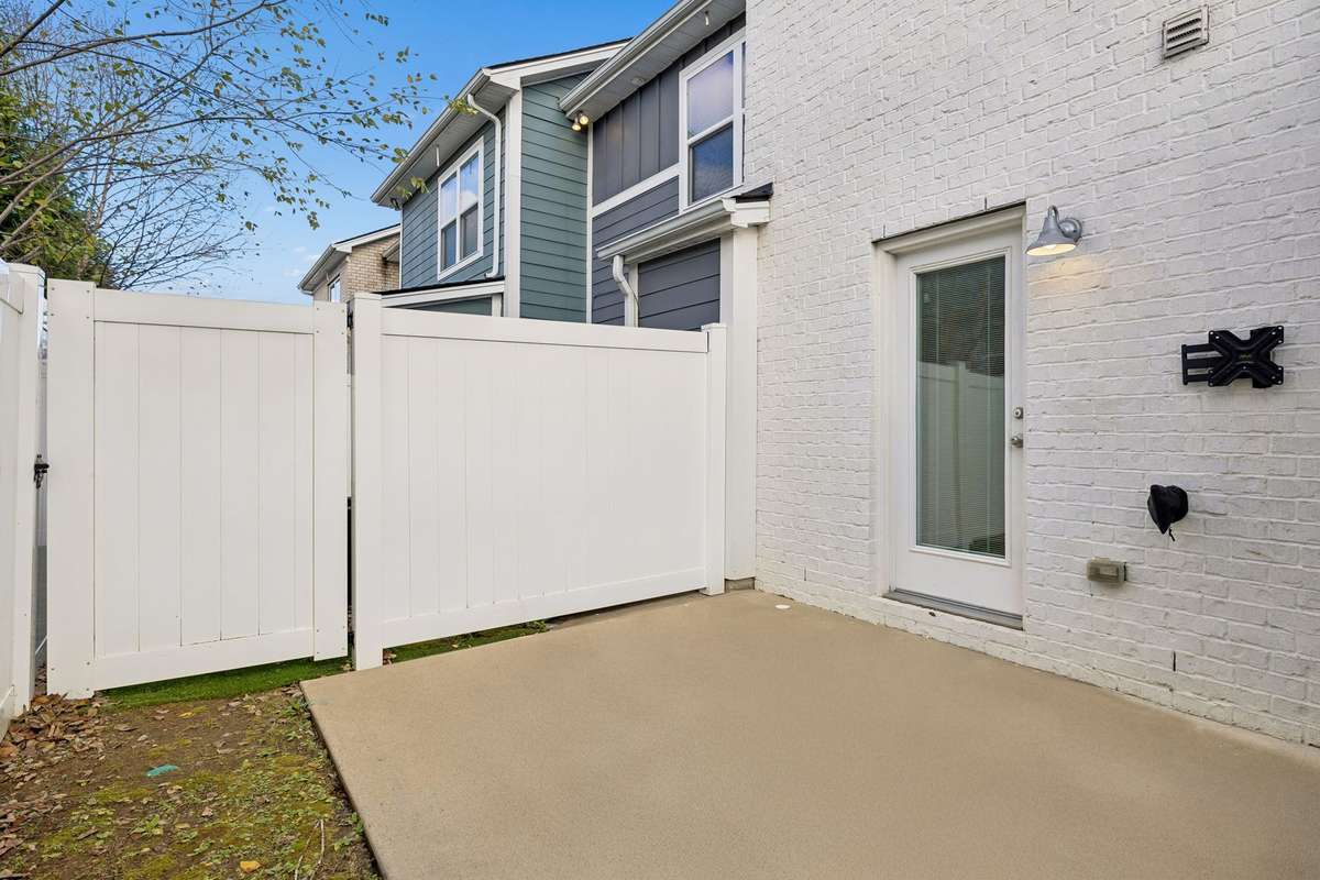 Private fenced back patio with a concrete pad—perfect for grilling, fire-pit evenings, or outdoor gatherings. Includes a convenient outdoor storage closet for added functionality.