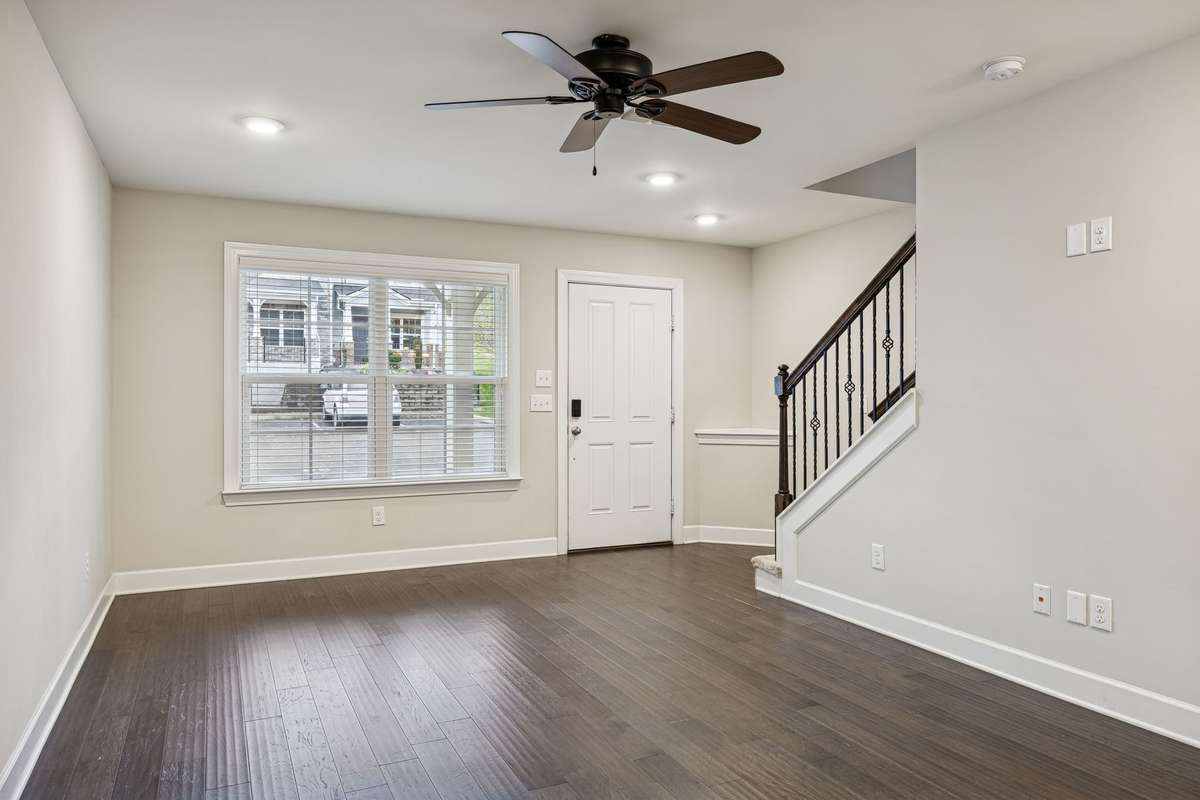 Bright and inviting living room featuring a large front window that fills the space with natural light and offers a view of the covered front patio.