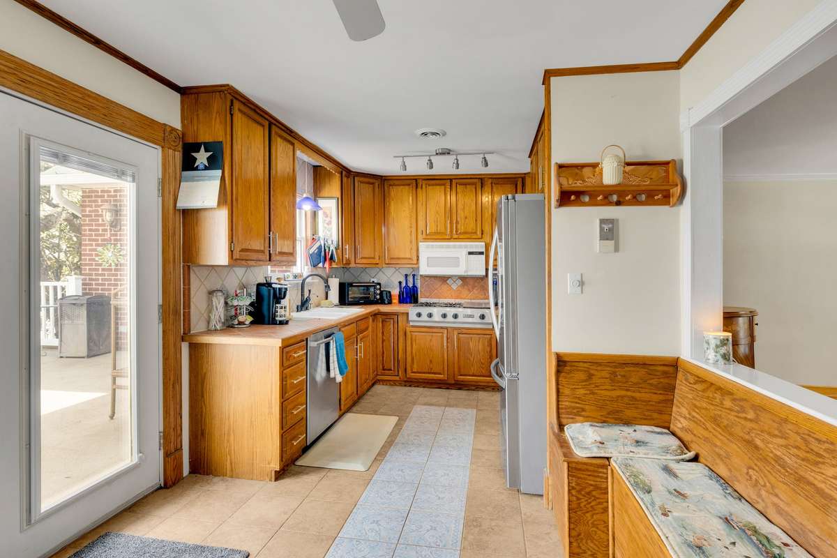 Kitchen custom tile and gas range. The wall between the kitchen and dining area could easily be opened up for an open concept