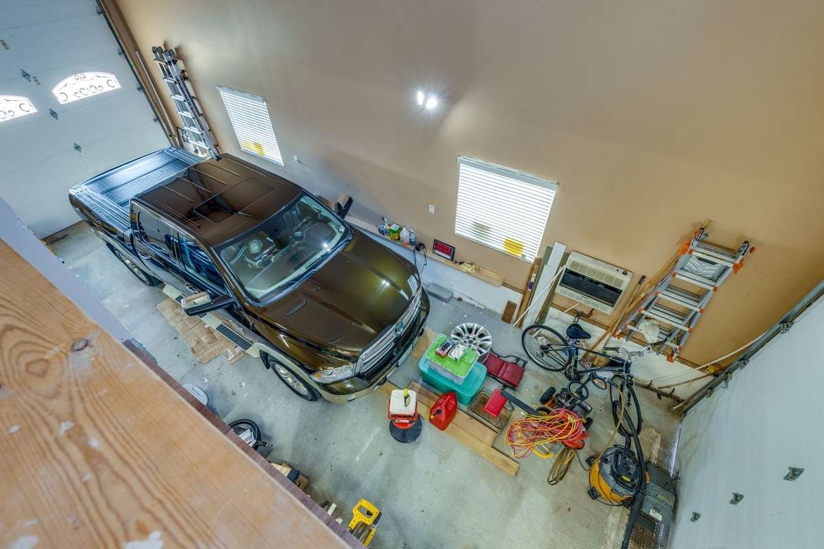 Great garage with a 14' door and 200 amp fuse ready for a lift. Drive through it to the other garage and carport.. • Insulated garage doors and propane heat