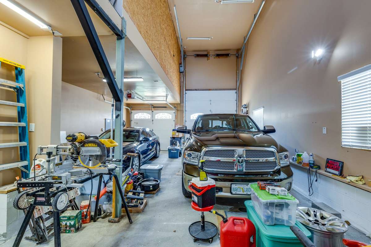 Great garage with a 14' door and 200 amp fuse ready for a lift. Drive through it to the other garage and carport.. • Insulated garage doors and propane heat