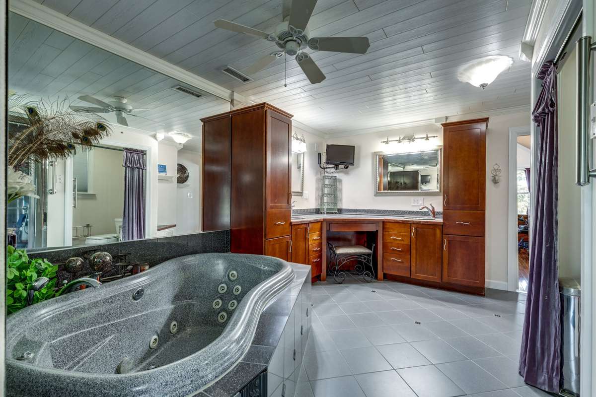 Large master bath with oversized whirlpool tub, steam shower, heat lamp, double vanities, and large walk-in closet