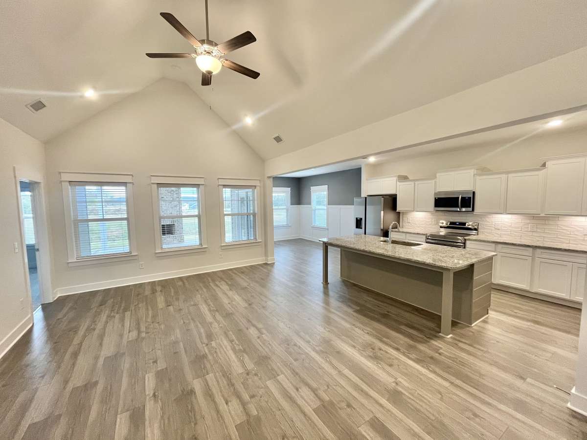Great room with cathedral ceiling open to kitchen and dining