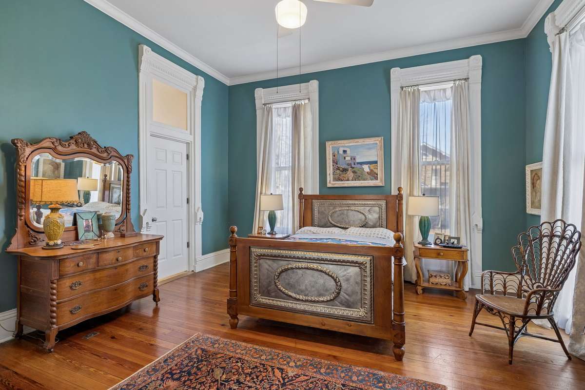 A spacious first-floor primary bedroom is en suite. Eleven-foot ceilings and 10-foot windows with original casings and transom doorways.
