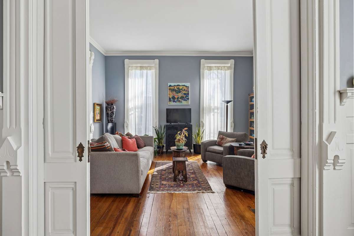 Large pocket doors with beautiful hardware provide privacy from the dining room to the living room/front parlor.