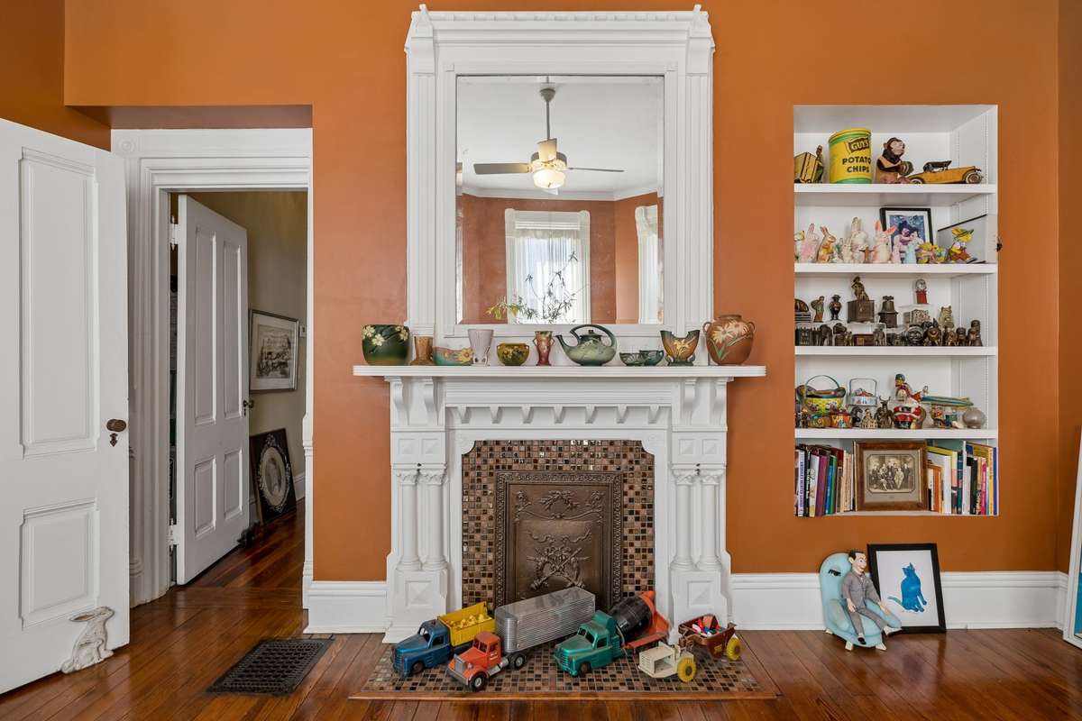 The office/parlor houses one of three fireplaces in the home, as well as built-in shelving.