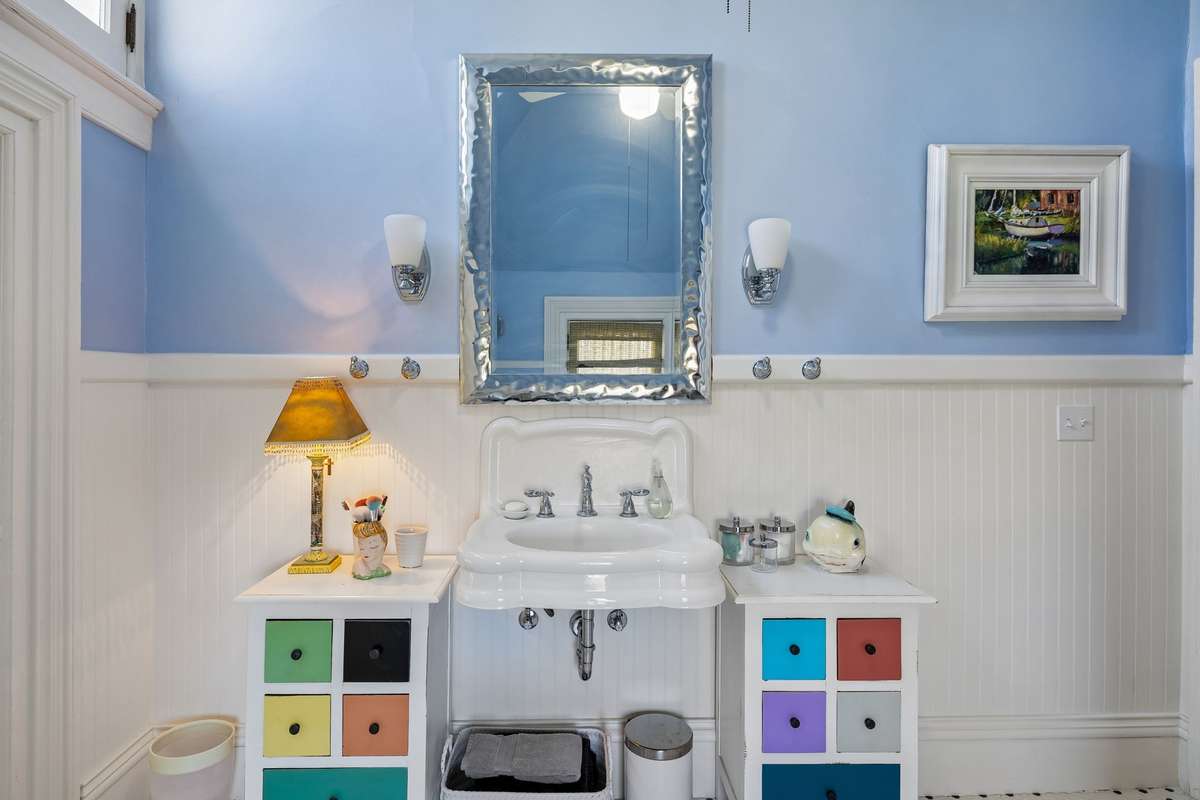 The vanity is surrounded by beadboard in the full bathroom on the second floor.