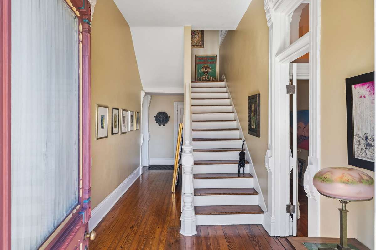 The home's entryway greets you with the warmth of the original hardwood floors and the elegant staircase leading up to several additional bedrooms