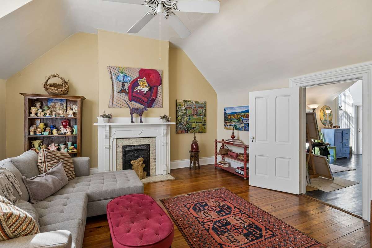 A welcoming and spacious second floor room that can be used as a living room or bedroom that leads to the art studio with a kitchen.