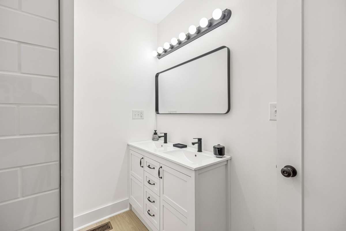 Double vanity with new mirror and light fixture in Primary en suite bathroom