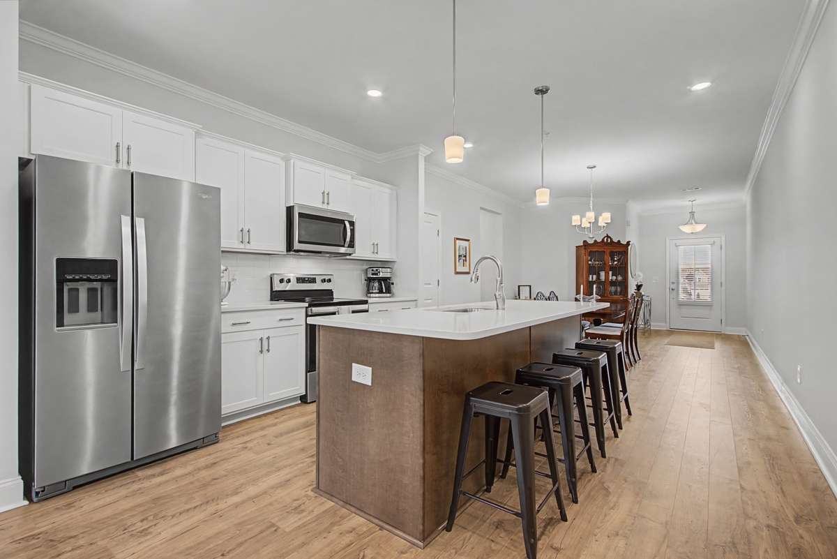 This incredible modern kitchen is both functional and beautiful.  The white shaker style cabinets contrast wonderfully with the island and shiny stainless appliances.