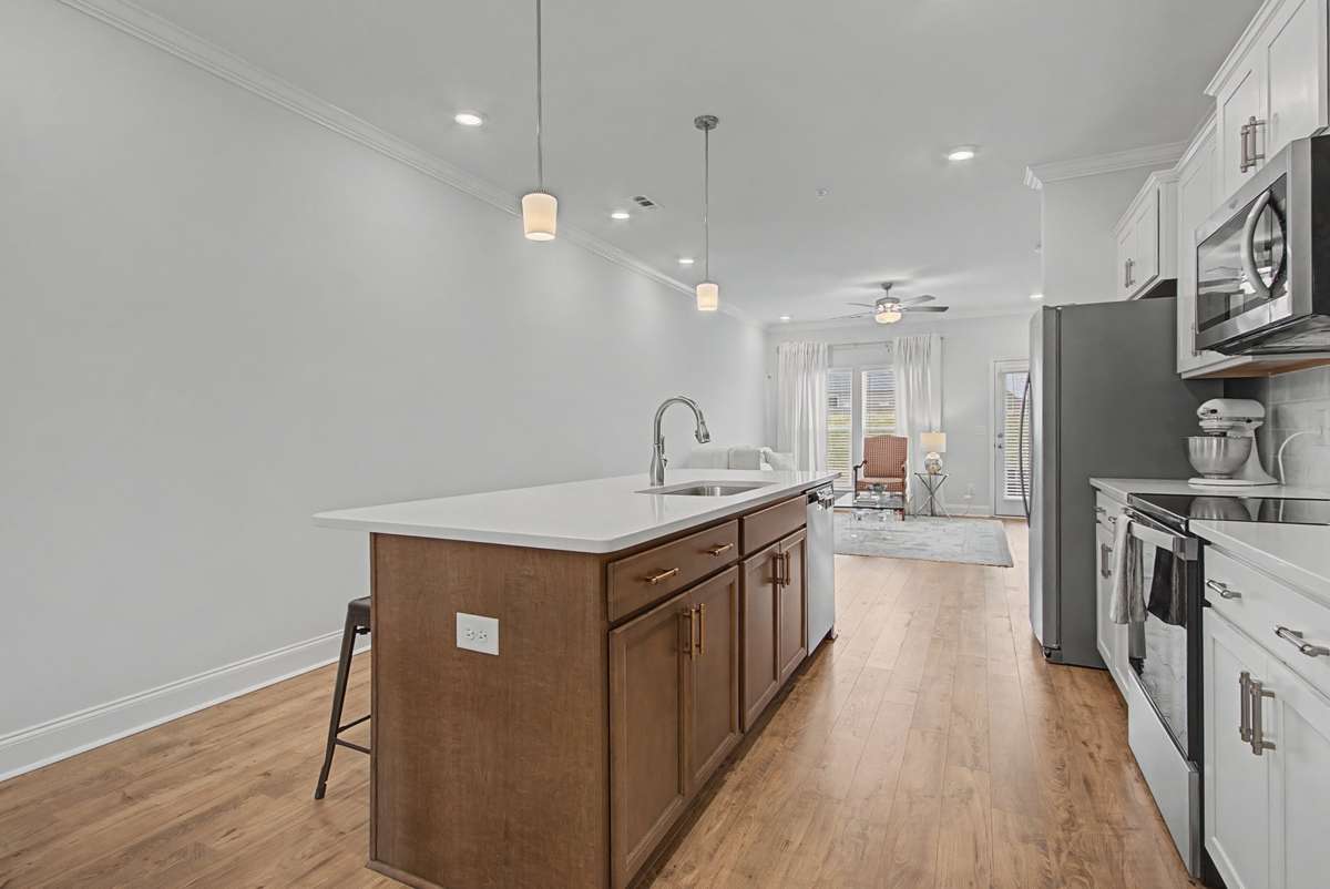 The large island is a beauty with stained maple wood and topped with that striking white quartz countertop.