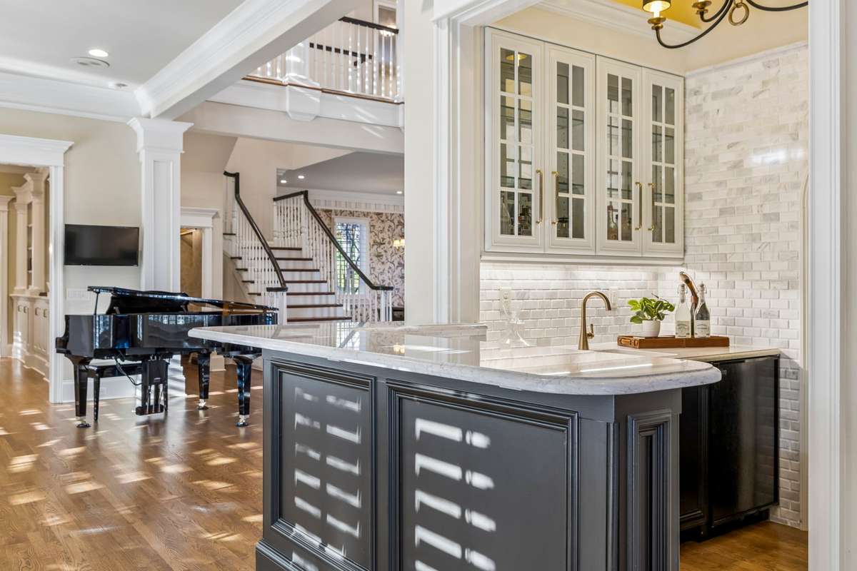 Open piano room with adjoining wet bar, ice maker, beverage fridge, and under cabinet lighting