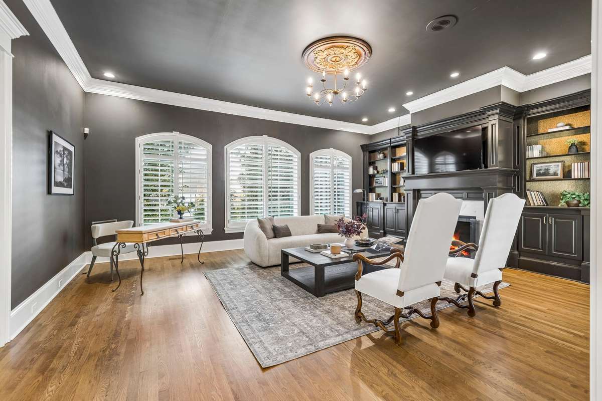 Private study with fireplace, custom built-ins, and pocket doors opening to the main level primary suite