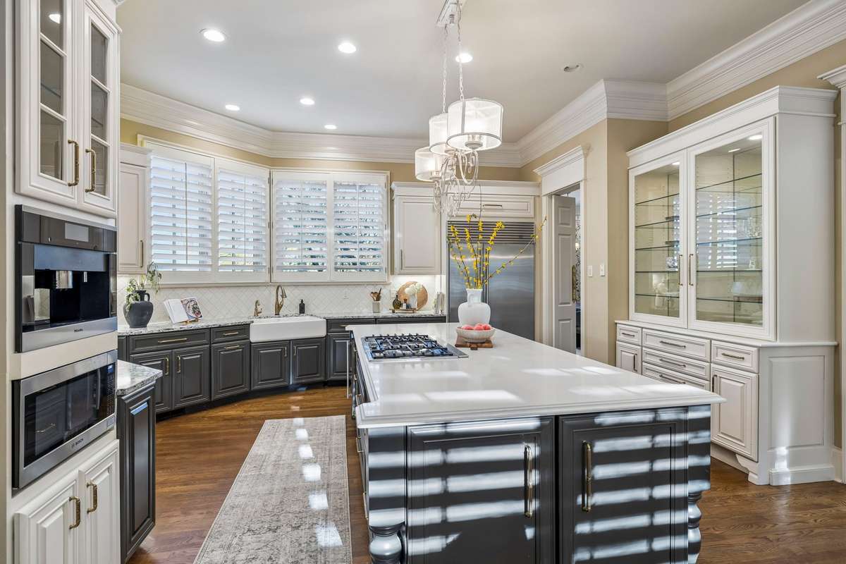 The kitchen is both refined and functional, centered around a 10-foot quartz island and complemented by premium appliances including Sub-Zero, Bosch, Miele and more.