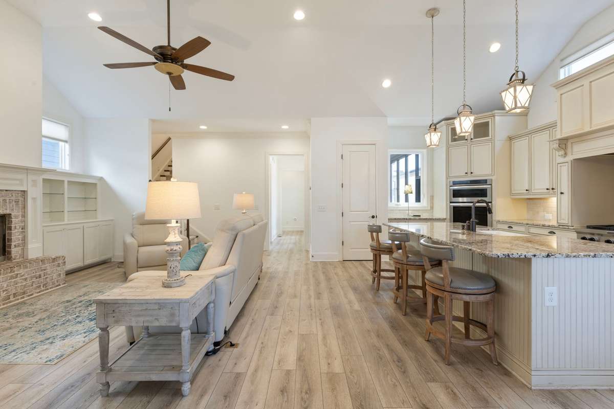 Light-filled living area featuring soaring ceilings and cozy fireplace