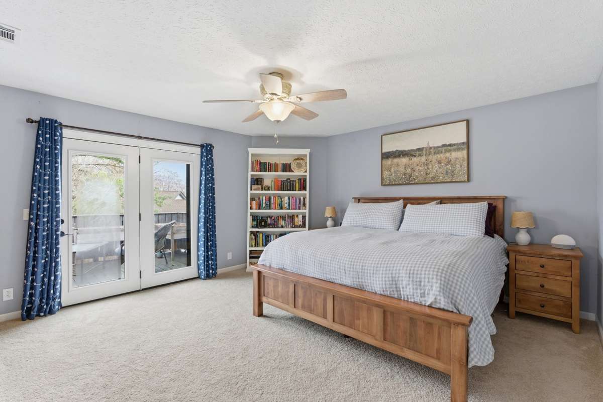 Upstairs primary bedroom with doors to upstairs deck.