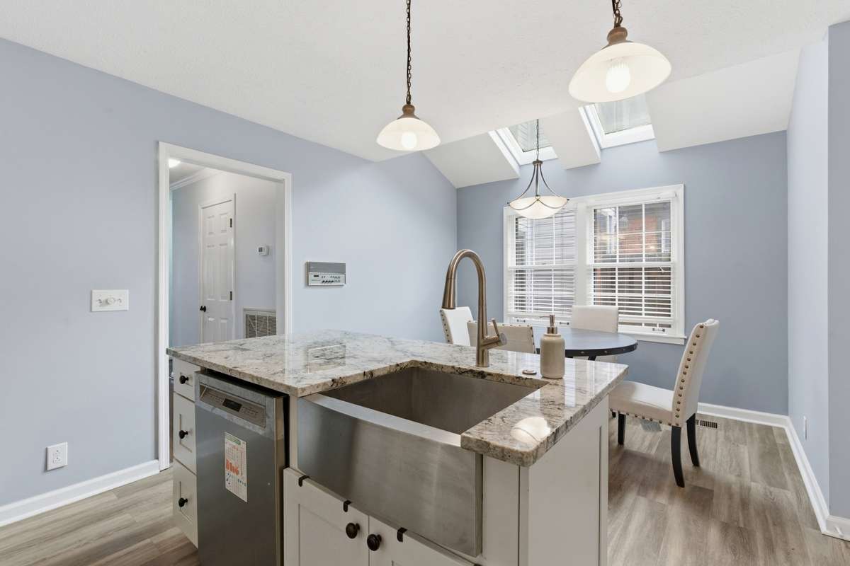 Kitchen island with dining area, skylights and windows to outside entryway.