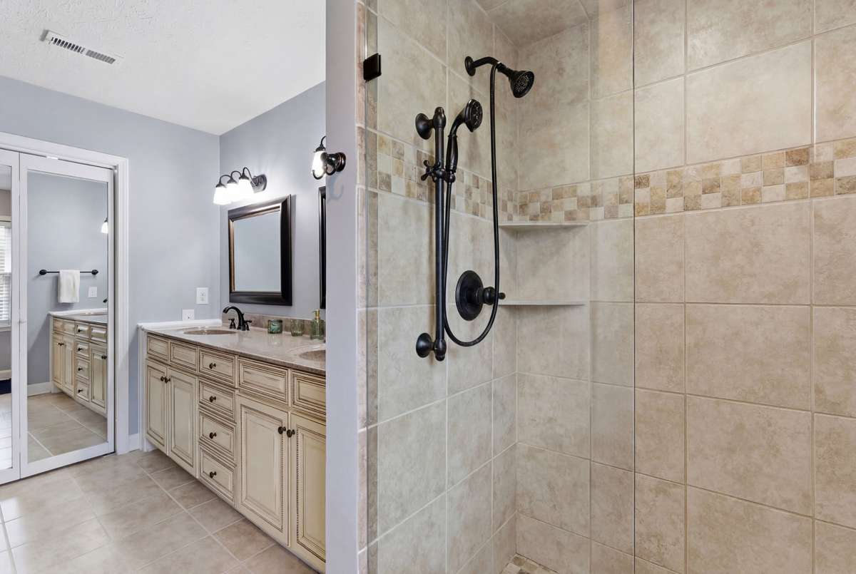 Primary bath showing walk-in shower. Walk-in closet behind mirrored doors.