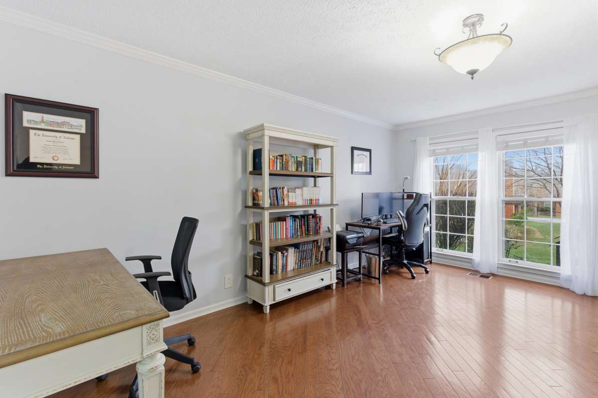 The dining room area from hallway to kitchen looking out windows. Living room area directly to the right.