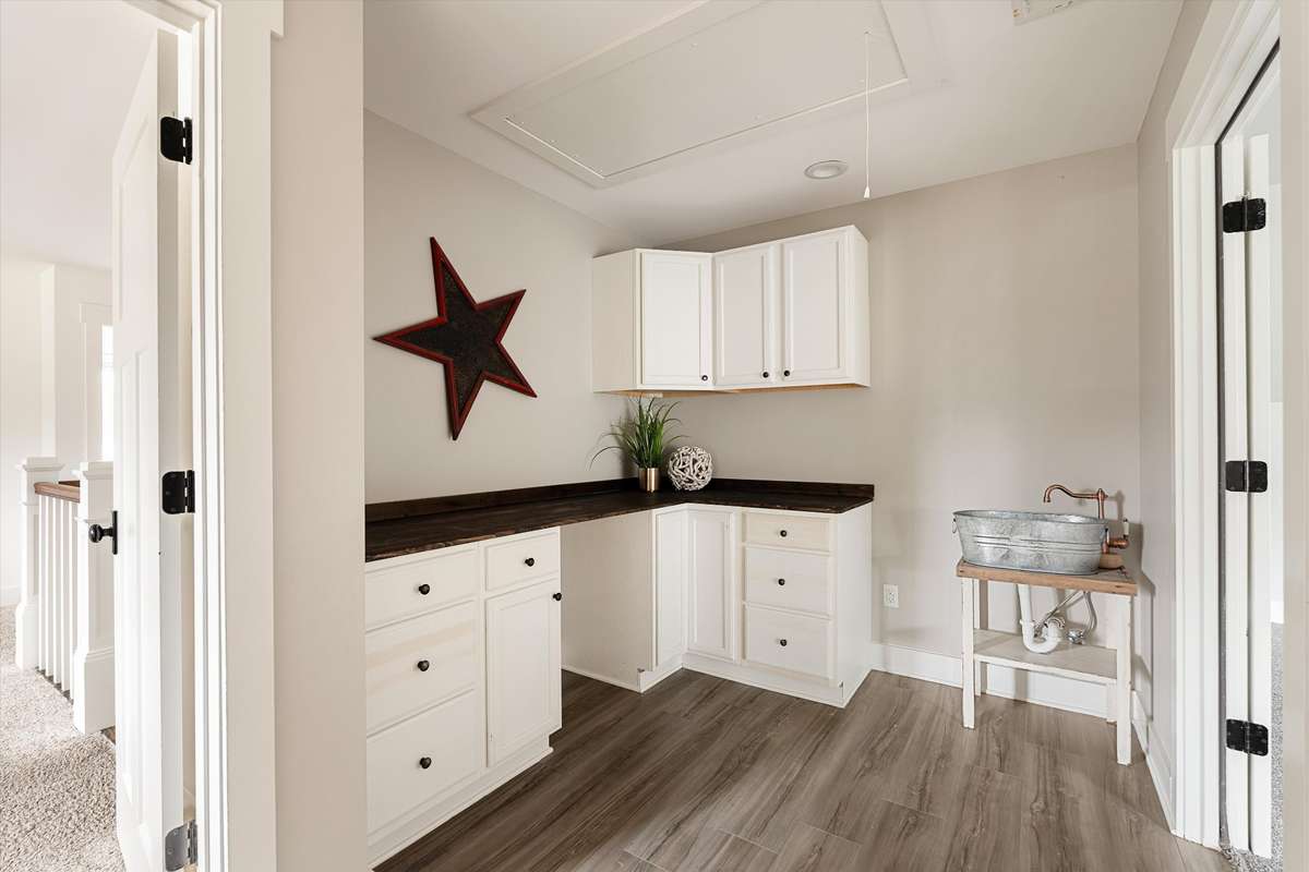 Off of the loft, is the hobby room with closet, cabinets, and a sink