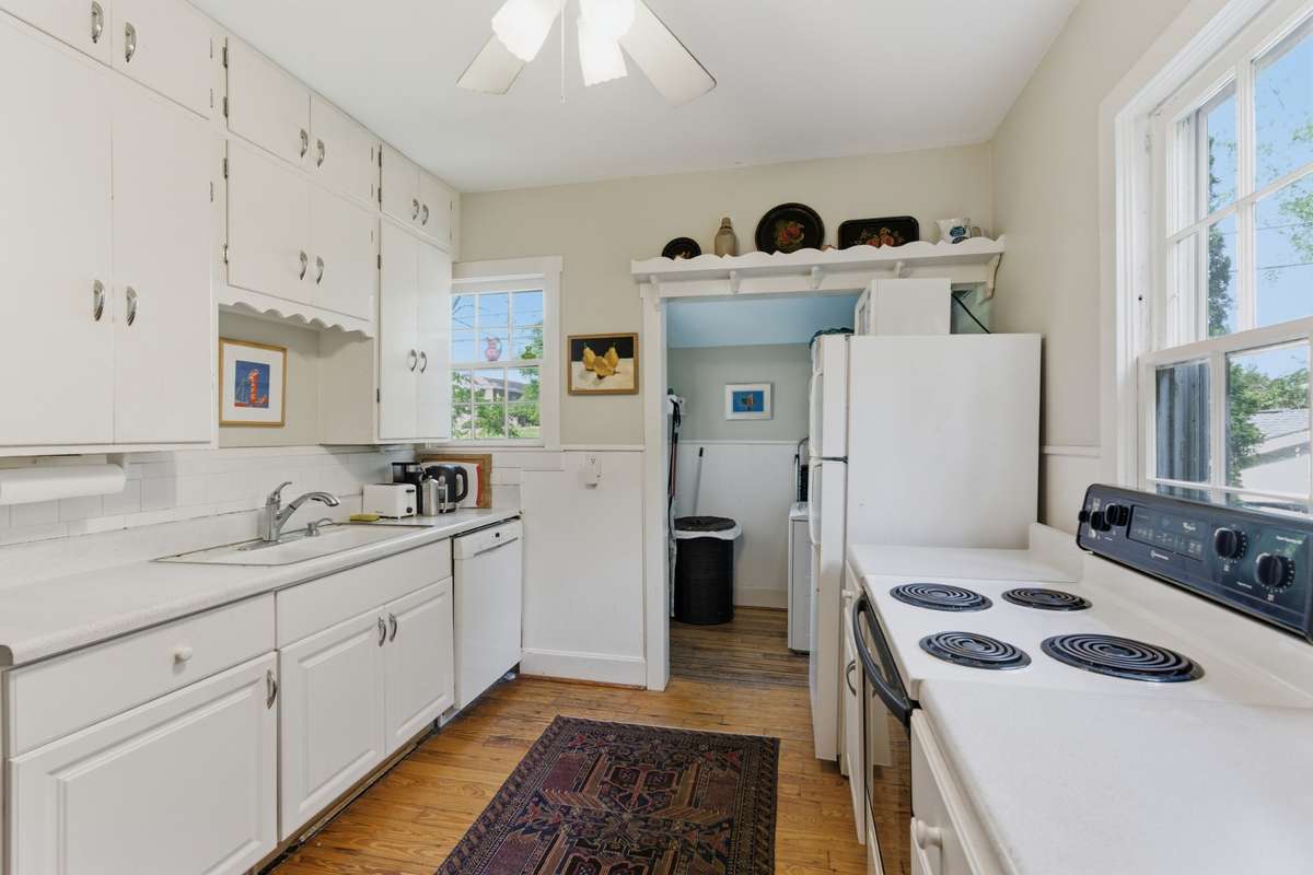Adorable 1930's kitchen has lots of cabinet storage and an attached utility room.