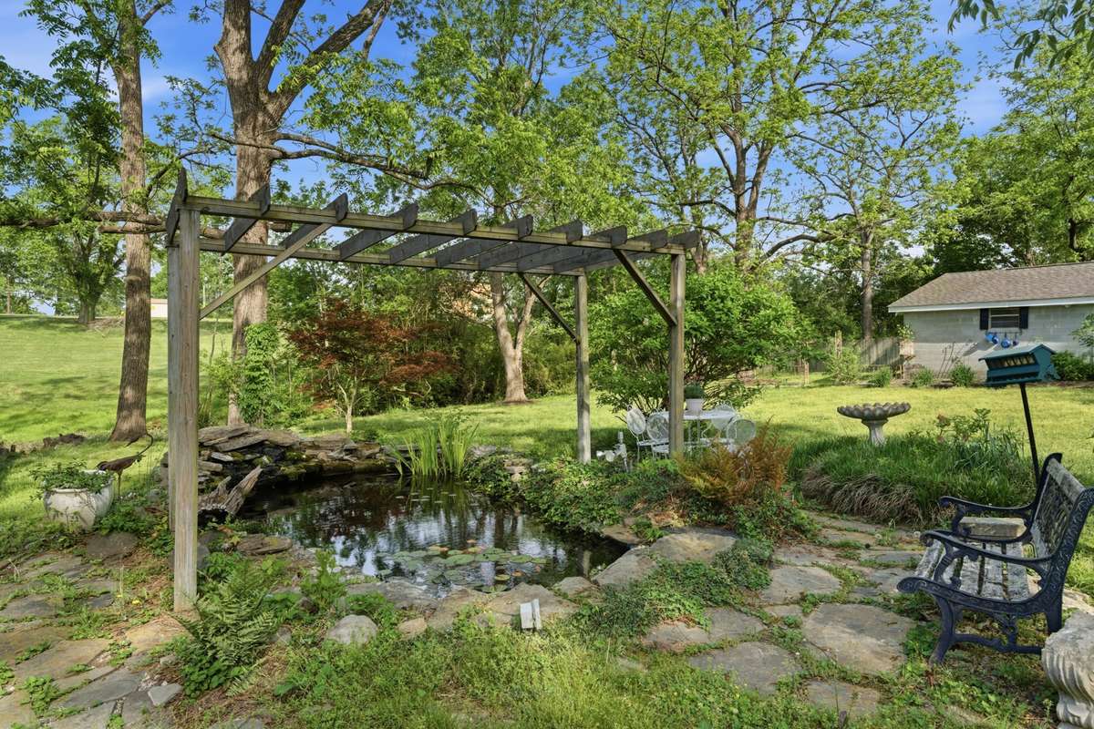 Sit back and enjoy the serenity of your own backyard with a live Koi pond and a sitting area.