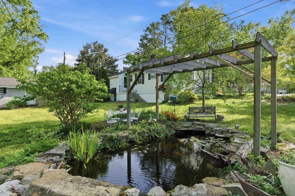 Sit back and enjoy the serenity of your own backyard with a live Koi pond and a sitting area.