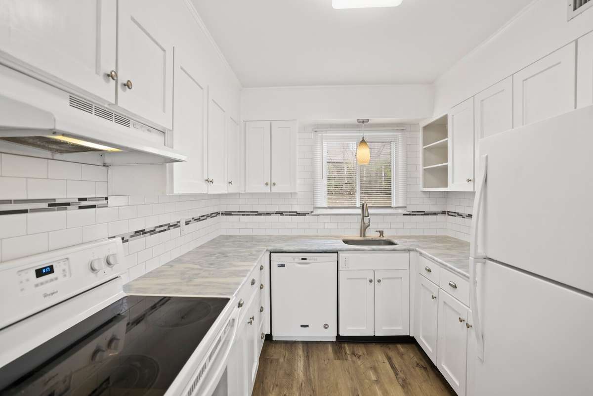 Kitchen with granite counter and tile backsplash.