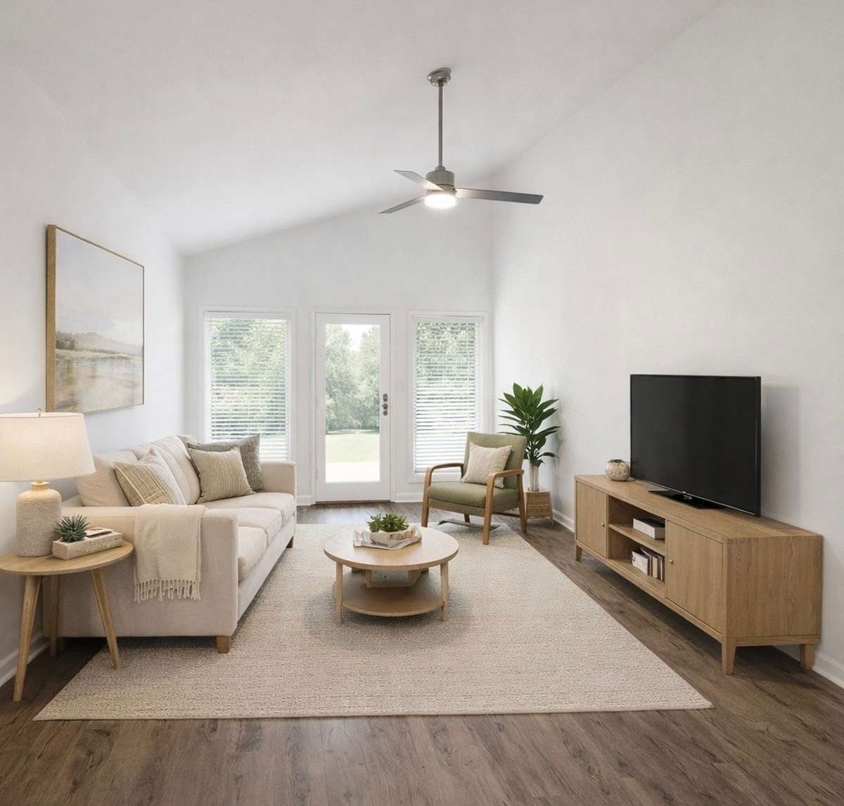 Vaulted ceiling living room with ceiling fan and lots of light to covered back porch. All freshly painted bright white, ceiling walls and trim. Blinds on windows.
