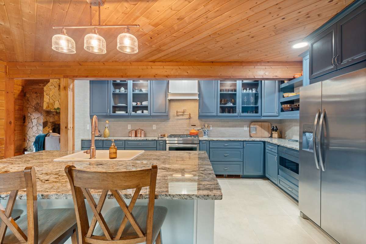 Newly renovated kitchen with JennAir gas cooktop and pot filler above stove.