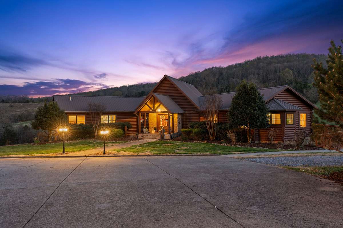 Stars and sunset light this log cabin at night