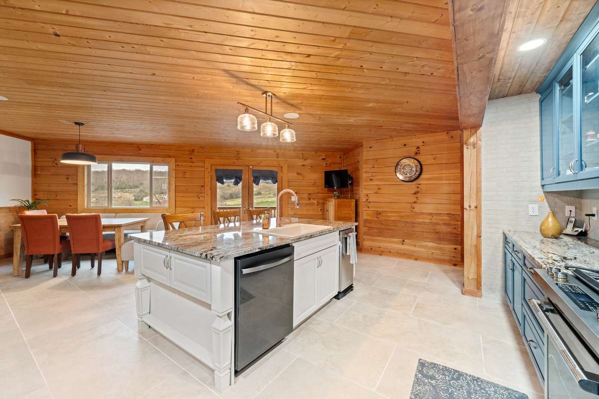 Large kitchen island complete with seating, dishwasher and trash compactor.