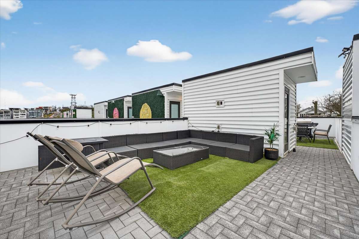 Take in stunning Nashville skyline views from the rooftop lounge—complete with a spacious outdoor sectional, fire pit table, and rocking chairs perfect for relaxing under the city lights.