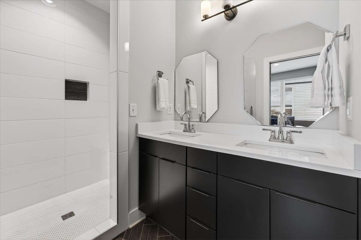 An adjoining bathroom with a double vanity offers plenty of space for guests to get ready with ease.