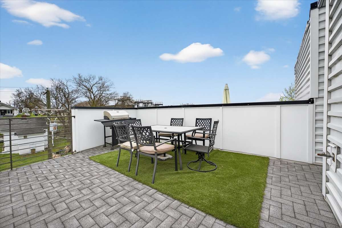 Step onto the rooftop and choose your view—this side features an outdoor dining area and gas grill, perfect for meals with the Nashville skyline as your backdrop.