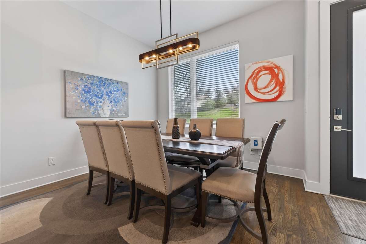 This expansive dining area, anchored by a stunning light fixture, comfortably seats eight—an ideal setup for hosting large groups, perfect for Airbnb guests looking for a spacious, welcoming spot to gather.